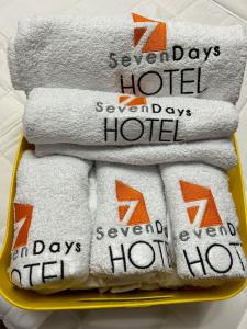 圣佩德罗苏拉SEVEN DAYS HOTEL B&B的床上装满毛巾的黄色托盘