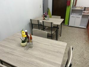 圣佩德罗苏拉SEVEN DAYS HOTEL B&B的用餐室配有2张桌子和椅子,鲜花盛开