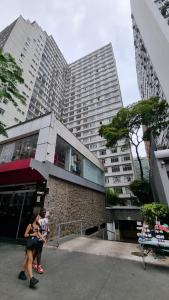 圣保罗Av. Paulista Trianon MASP的两个人在高楼前走