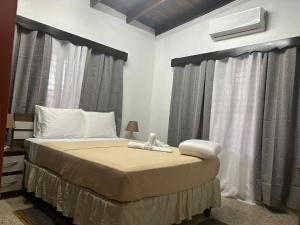 圣佩德罗苏拉SEVEN DAYS HOTEL B&B的一间卧室配有一张带窗帘的大床