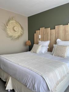 拉波勒Hôtel BO & MIA的卧室配有一张带白色床单和枕头的大床。