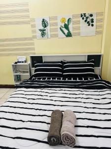 Ban Khlong Phutsaบ้านบุษยา的一张黑白床,带两条毛巾