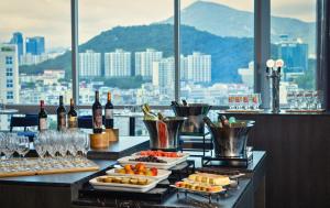 釜山广安里凯星顿肯特酒店的一间酒吧,提供食物和葡萄酒,享有城市美景