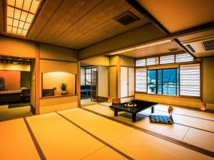 下吕市Yukai Resort Gero Saichoraku Bekkan的一间亚洲客房,配有桌子和窗户