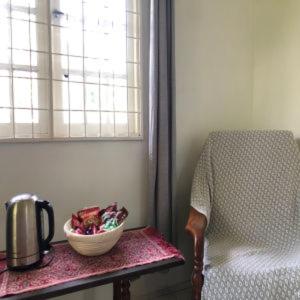 LunduBasari Guest House的椅子和窗户旁的碗