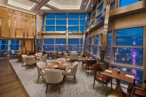 上海上海金茂君悦大酒店的餐厅设有桌椅和大窗户。