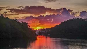 波尔多·格尼拉水滨潜水&温泉度假酒店的日落在河流上,阳光照耀