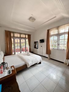 巴利盖Hotel Ompu Herti的一间大卧室,配有一张大床和窗户