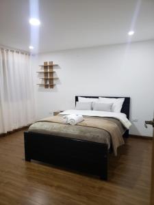 昆卡Departamento completo con hermosa vista de la ciudad的卧室配有一张带白色墙壁的大床
