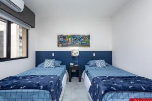 圣保罗LFlats no Hotel Aeroporto Congonhas的一间卧室设有两张床,墙上挂着一幅画