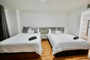 迈阿密City & Sea View+FREE Parking Modern Condo的配有白色墙壁和木地板的客房内的两张床