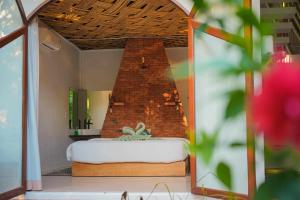 班奥南矛Aloe Ecological Boutique Villa 2的砖砌壁炉间内的一张床位