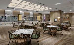 新山Hyatt Place Johor Bahru Paradigm Mall的一间在房间内配有桌椅的餐厅