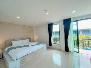拉威海滩Natthawan Pool Access Rawai的一间卧室设有一张床和一个大窗户