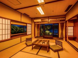 那智胜浦町Yukai Resort Premium Koshinoyu的客房设有桌椅和窗户。