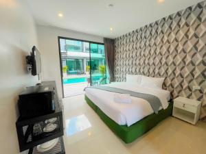 拉威海滩Natthawan Pool Access Rawai的一间卧室配有一张床和一台电视。