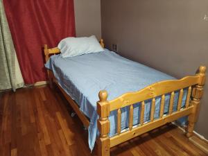 圣安娜OC House的一张带蓝色棉被和枕头的木床