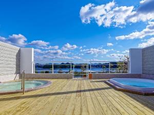白滨Yukai Resort Premium Shirahama Saichoraku的甲板上设有2个热水浴池的房子