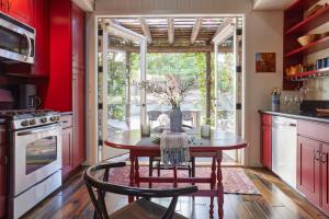 La Canada FlintridgeGuest Oasis on the edge of Los Angeles的厨房配有红色橱柜和木桌及椅子