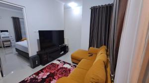 巴图Villa Terrace Batu Malang Kav 4的客厅设有黄色沙发和电视