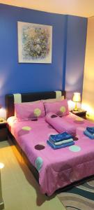 波德申可可湾放松公寓的一间卧室配有粉红色的床和粉色毯子