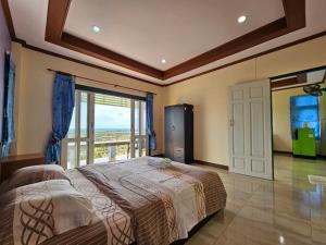 素叻Baan Khao Noi Resort的一间卧室设有一张床,享有海景