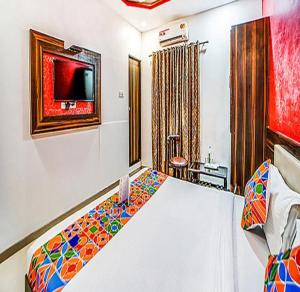 孟买FabHotel The Adore Palace的卧室配有一张床,墙上配有电视。