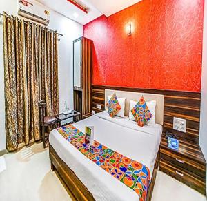 孟买FabHotel The Adore Palace的一间卧室设有一张床和红色的墙壁