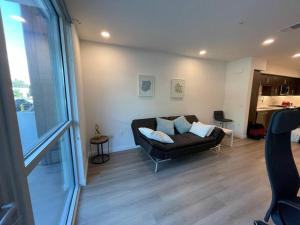 尔湾Luxurious Apartment Bardeen New Port Beach 1 Bedroom的一间带黑色沙发的客厅和一间厨房