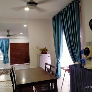 Tanjung KarangSri Manik Guest House Tanjung Karang的一间配备有桌子和蓝色窗帘的用餐室