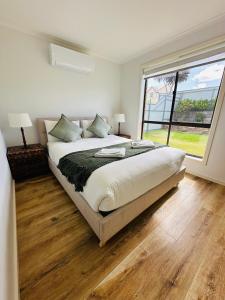 金斯科特Kangaroo Island Homestays的一间卧室设有一张大床和一个大窗户
