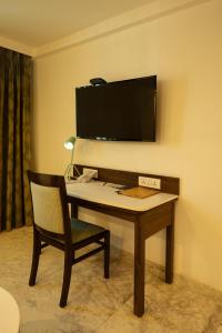 浦那Fairfield by Marriott Pune Kharadi的一张桌子、椅子和墙上的电视