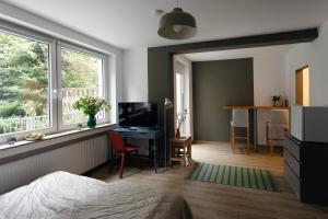 杜伊斯堡Central apartment with Terrace的一间卧室配有一张床、一张书桌和一个窗户。