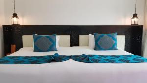 华欣华欣马拉喀什Spa度假酒店的一张带蓝色枕头的大型白色床