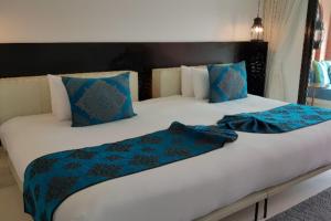 华欣华欣马拉喀什Spa度假酒店的一张配有蓝色和白色床单及枕头的大床