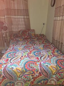 南迪awesome stay的卧室里一张床上有五颜六色的毯子