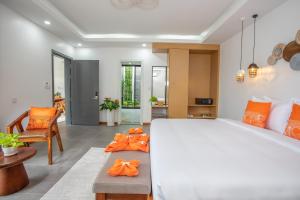 西哈努克Wonderland Suites and Resort的卧室配有白色大床和橙色枕头。