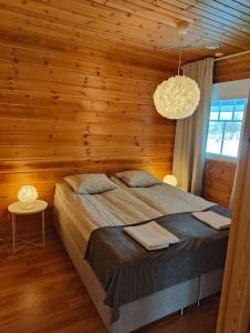 萨利色尔卡Twin Peaks Urupää B Saariselkä的一间卧室设有一张床和木墙