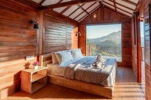 库布盼洛坎kamaani cabin的一间卧室设有一张床和一个大窗户