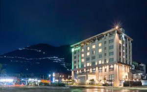 格德拉Holiday Inn Katra Vaishno Devi, an IHG Hotel的夜晚的酒店,以山为背景