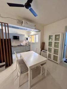 瓦斯科达伽马Good Stay Premium 2 BHK Apartment 103的厨房里设有白色的餐桌和椅子