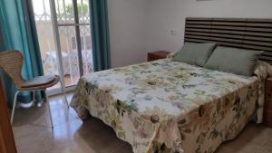卡耐特蒂贝兰格Apartamento con piscina y cerca de la playa的一间卧室配有一张带花卉床罩的床