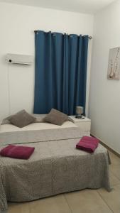 马略卡岛帕尔马Home & Away的一间卧室配有两张床和蓝色窗帘