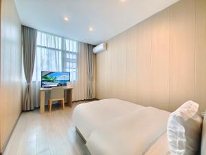 简阳不晚民宿(天府国际机场店)的酒店客房配有一张床、一张书桌和一台电视。