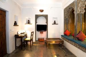 乌代浦马德里哈维里酒店的带沙发、书桌和电视的客厅