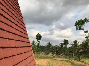 KotarajaMuni's Terrace Bungalow的一座有树木的建筑的红色屋顶