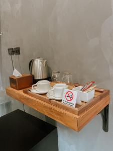 合艾Tachang Airport Hotel的一张带餐具的木桌和禁止吸烟的标志