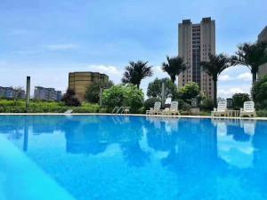 长沙湖南佳兴世尊酒店的一座带椅子和建筑的大型蓝色游泳池