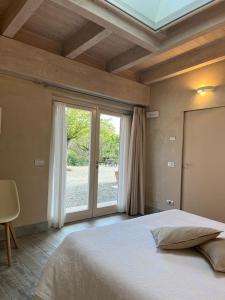 阿奎泰尔梅Il Sambuco Innamorato的一间卧室设有一张大床和一个大窗户