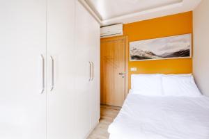 安塔利亚Flat w Balcony 5 min to Beach in Kemer的卧室配有白色的床和橙色的墙壁